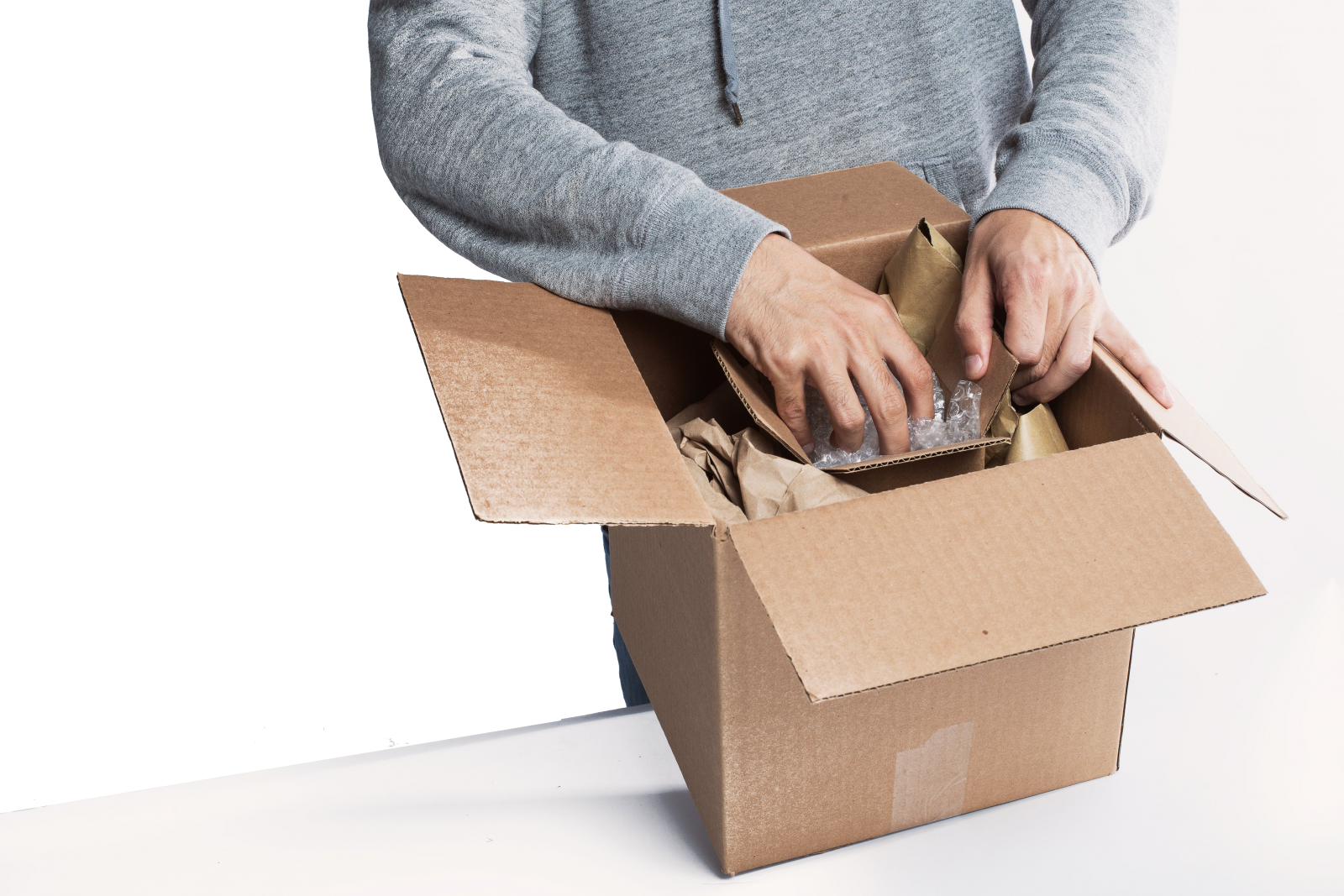 A person packs a box with small items
