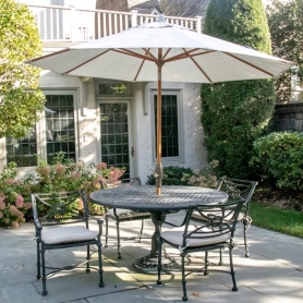 A pretty metal bistro-style outdoor dining set is the centerpiece of this pretty backyard patio. | BRG
