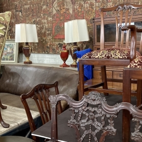 A vignette of antiques including chairs, lamps, leather sofa, oversized painted screens inside the Showroom at BRG-Bridgeport. | BRG