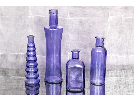 Decorative Collection Of Four Purple Hued Glass Vases