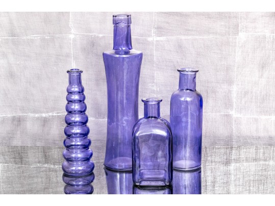 Decorative Collection Of Four Purple Hued Glass Vases