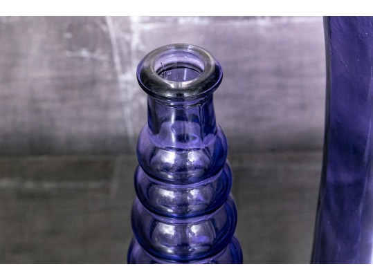Decorative Collection Of Four Purple Hued Glass Vases
