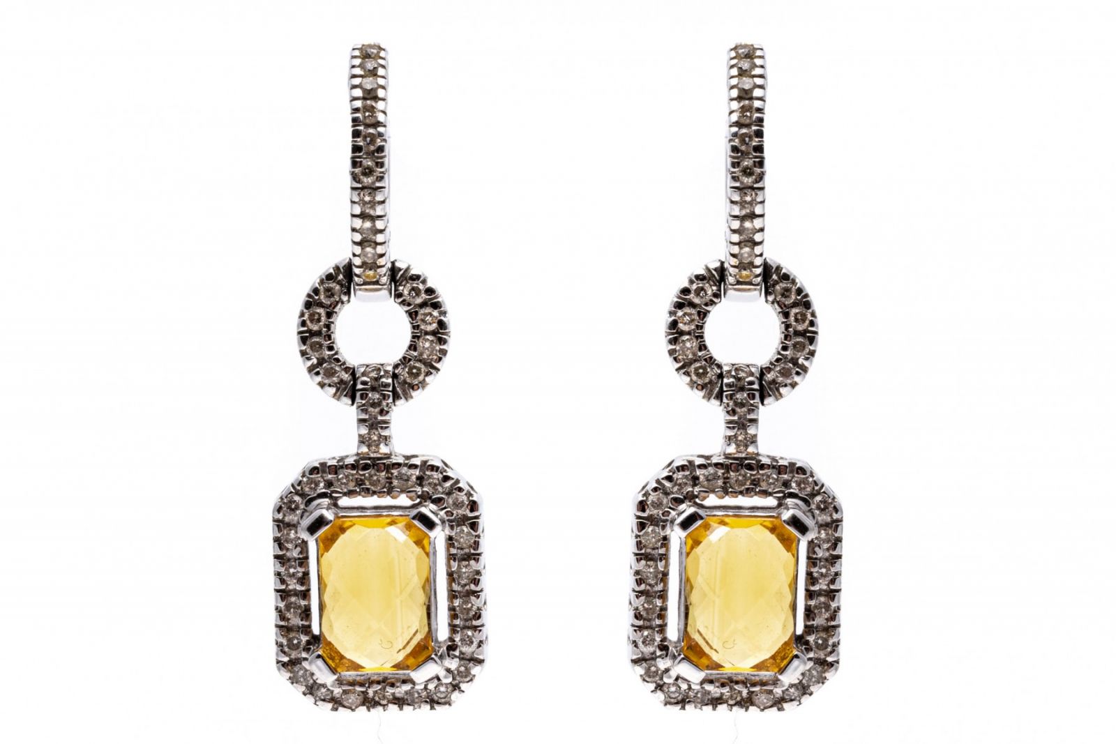 14K white gold dangle earrings set with rectangular cut citrines displaying a light pineapple yellow. Framing the citrines are round cut diamonds.