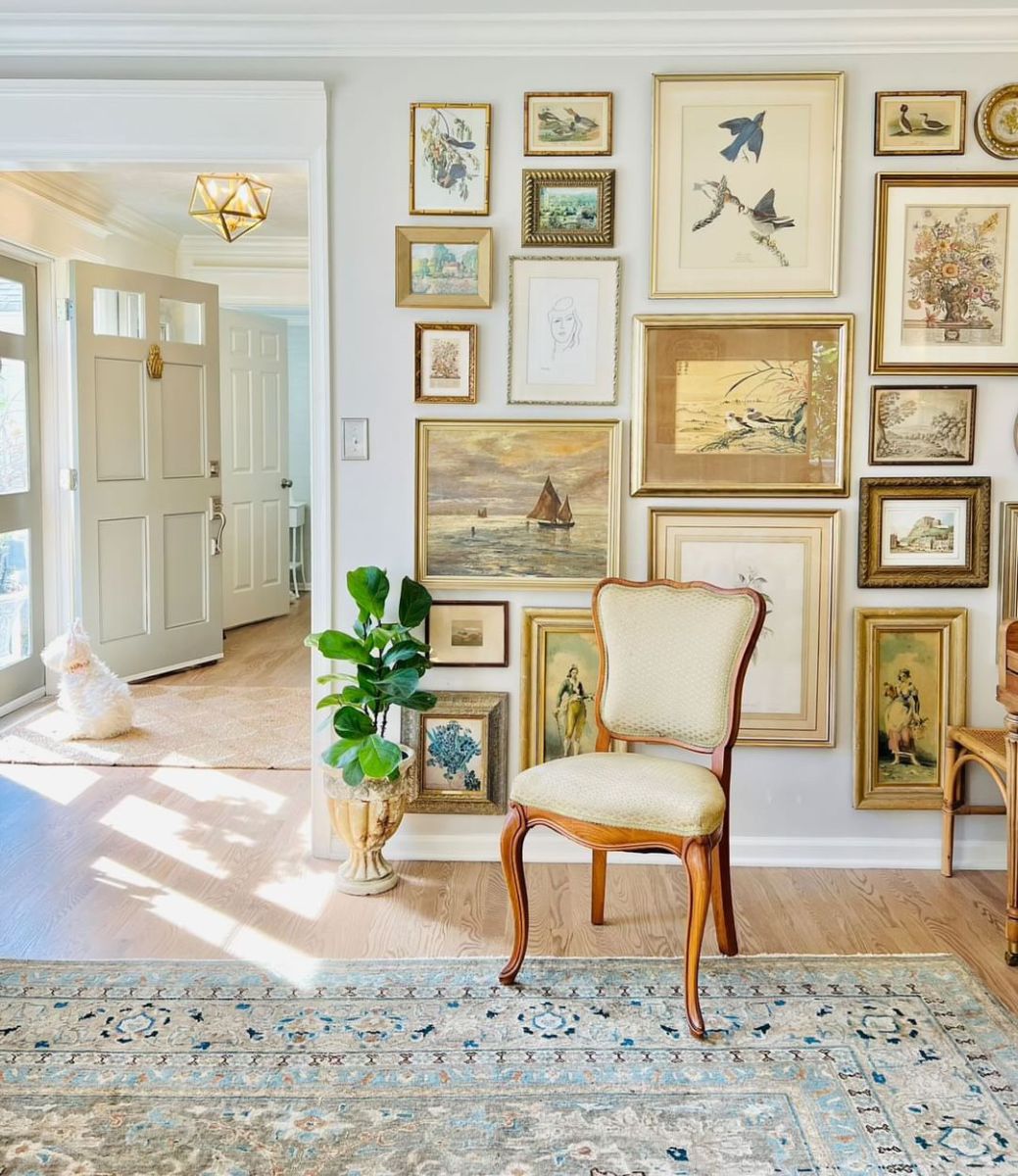 Sally stands gracefully in front of her gallery wall, adorned in a stunning navy gown, her smile radiating warmth and elegance.